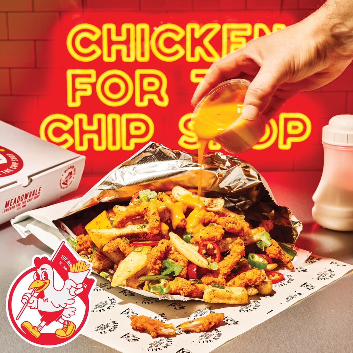 curry sauce being drizzled on chicken and chips